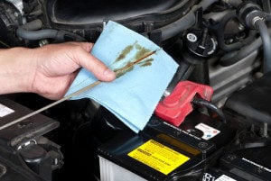 image of mechanic hand with cloth and oil dipstick.