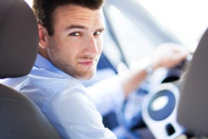 Some inspection tips for you to find out if a car is flood-damaged - AAMCO Colorado image of guy looking at you from driver side, interior of car.