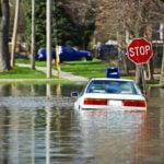 image of car at stop sign flooded intersection 1024