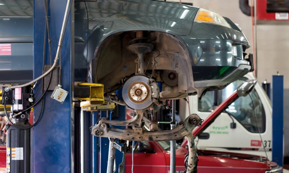 image of a car on lift getting maintenance and repairs