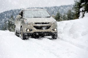 image of suv driving on snow packed mountain road