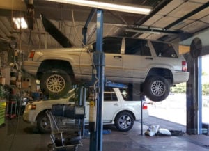 image of AAMCO Arvada interior service bay jeep cherokee on lift