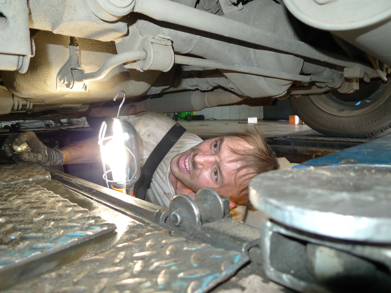 image of man inspecting undercarriage of vehicle