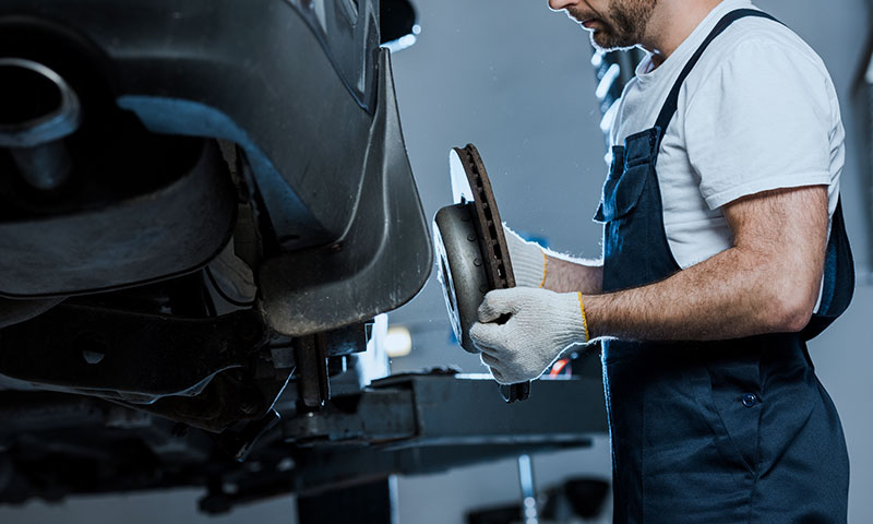 image of mechanic installing new brakes into a vehicle